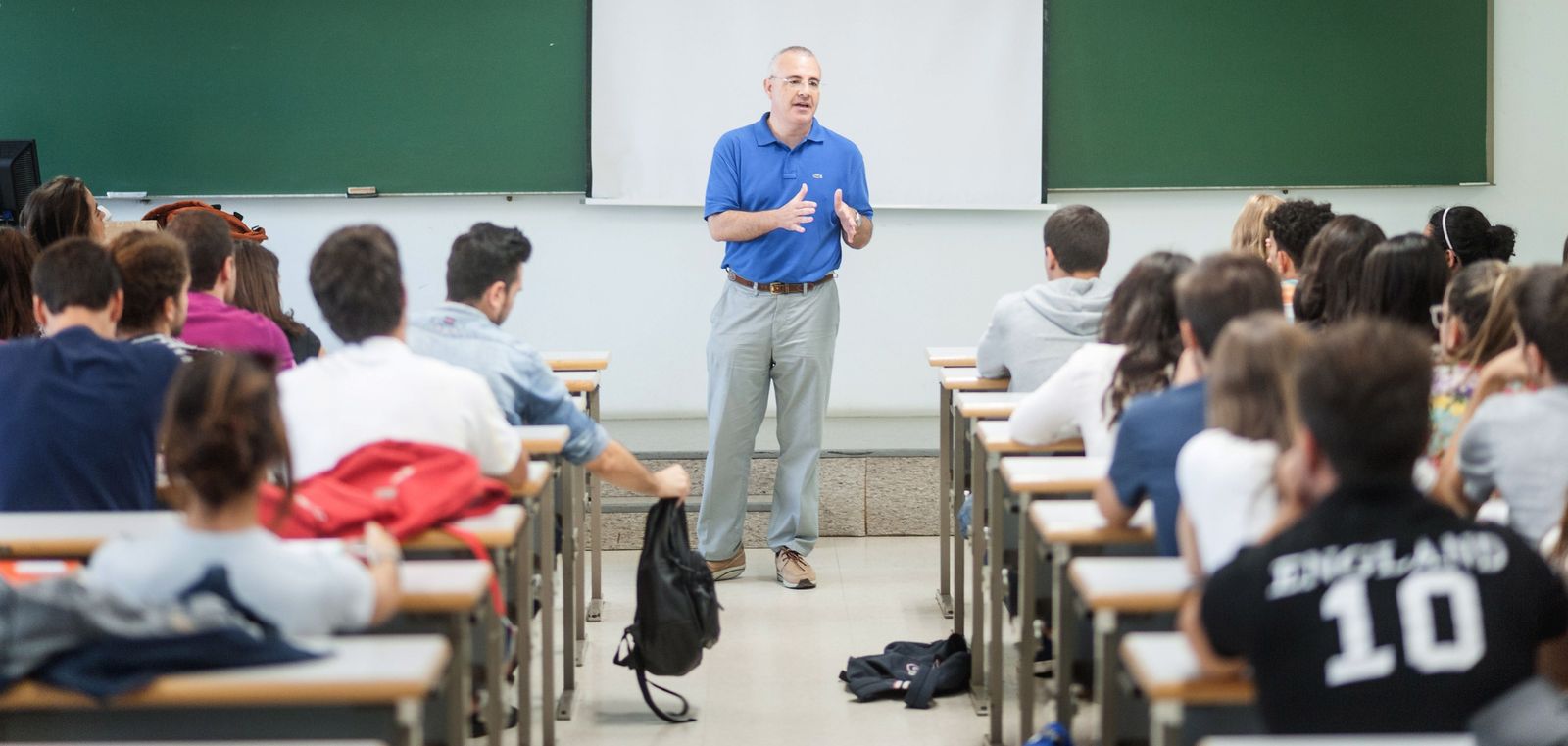 Profesor en un aula imparte materia. Foto de archivo