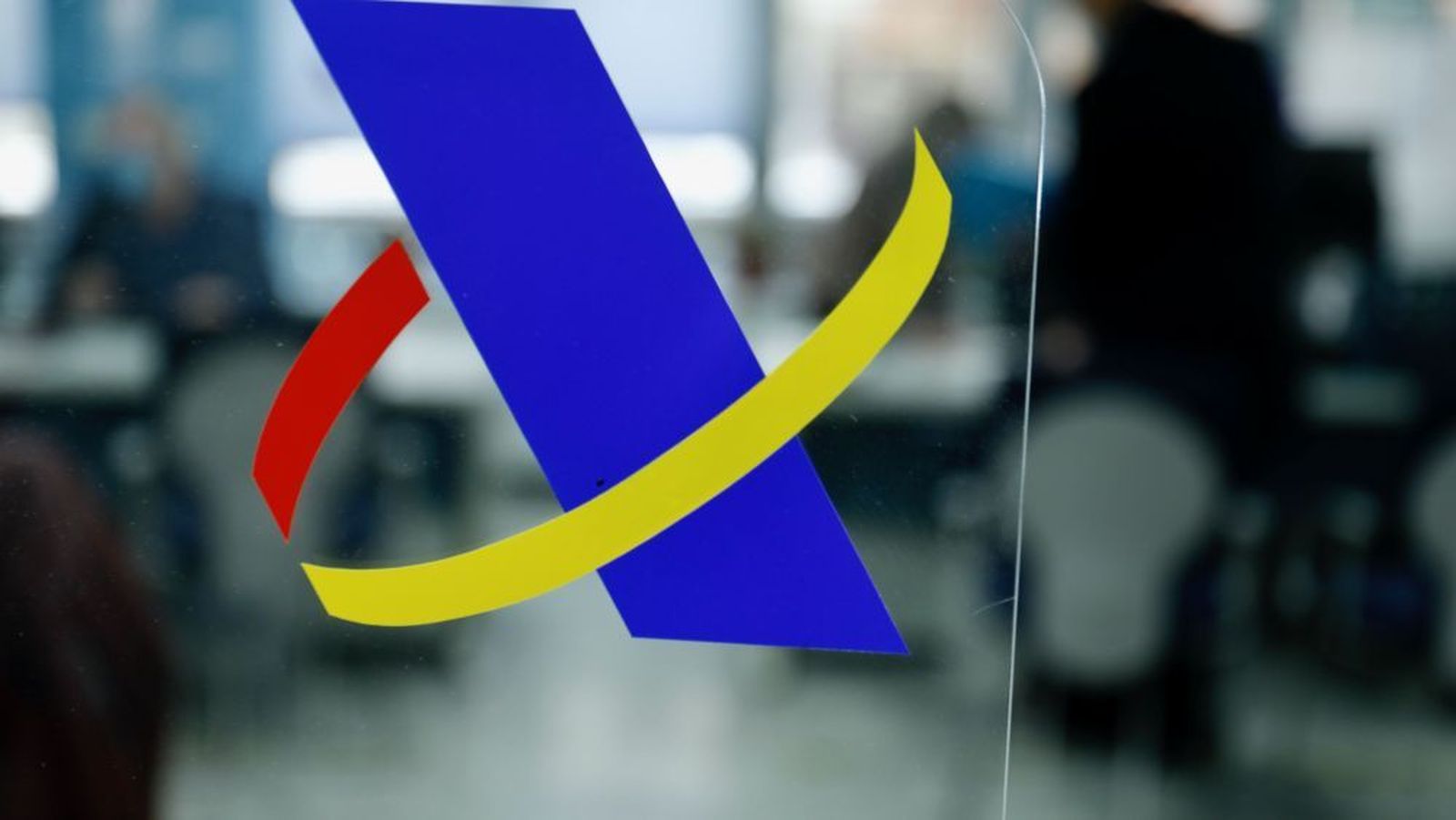 Logotipo de la Agencia Tributaria en la mampara de una oficina de Hacienda. Foto EP