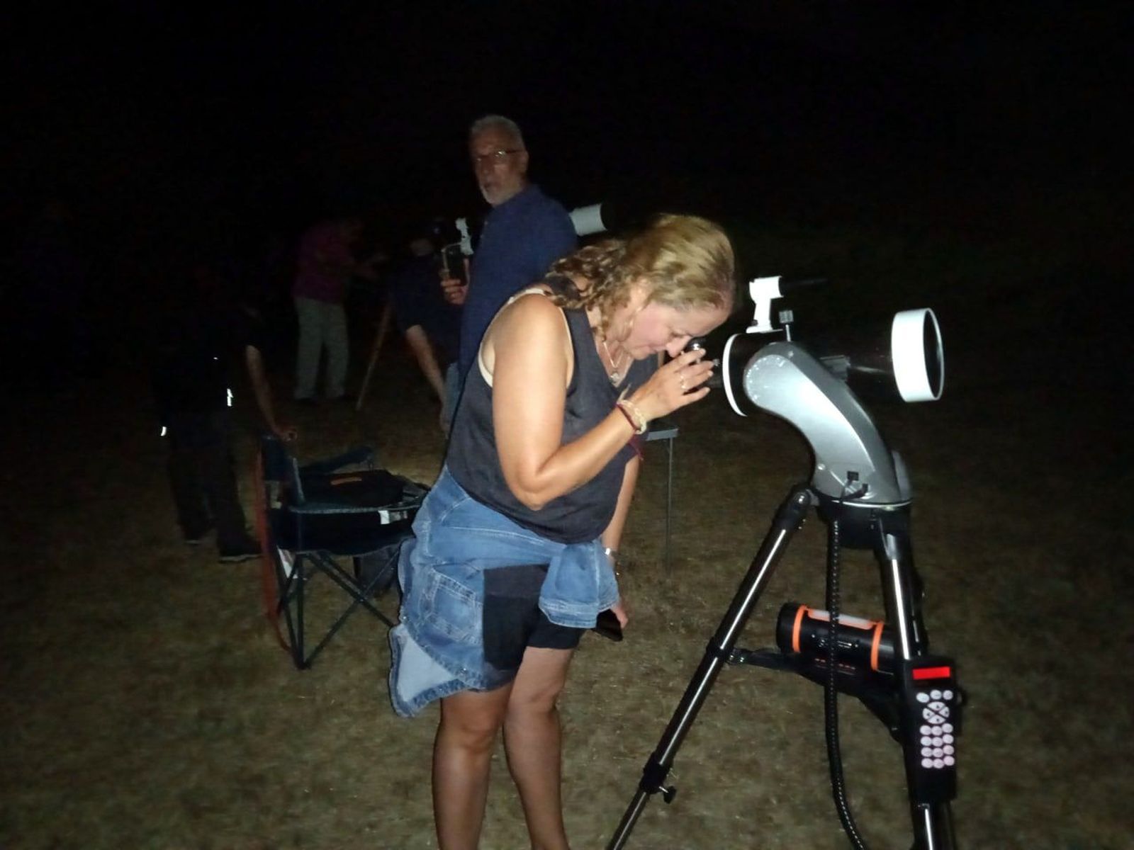 Una mujer observa a través de un telescopio