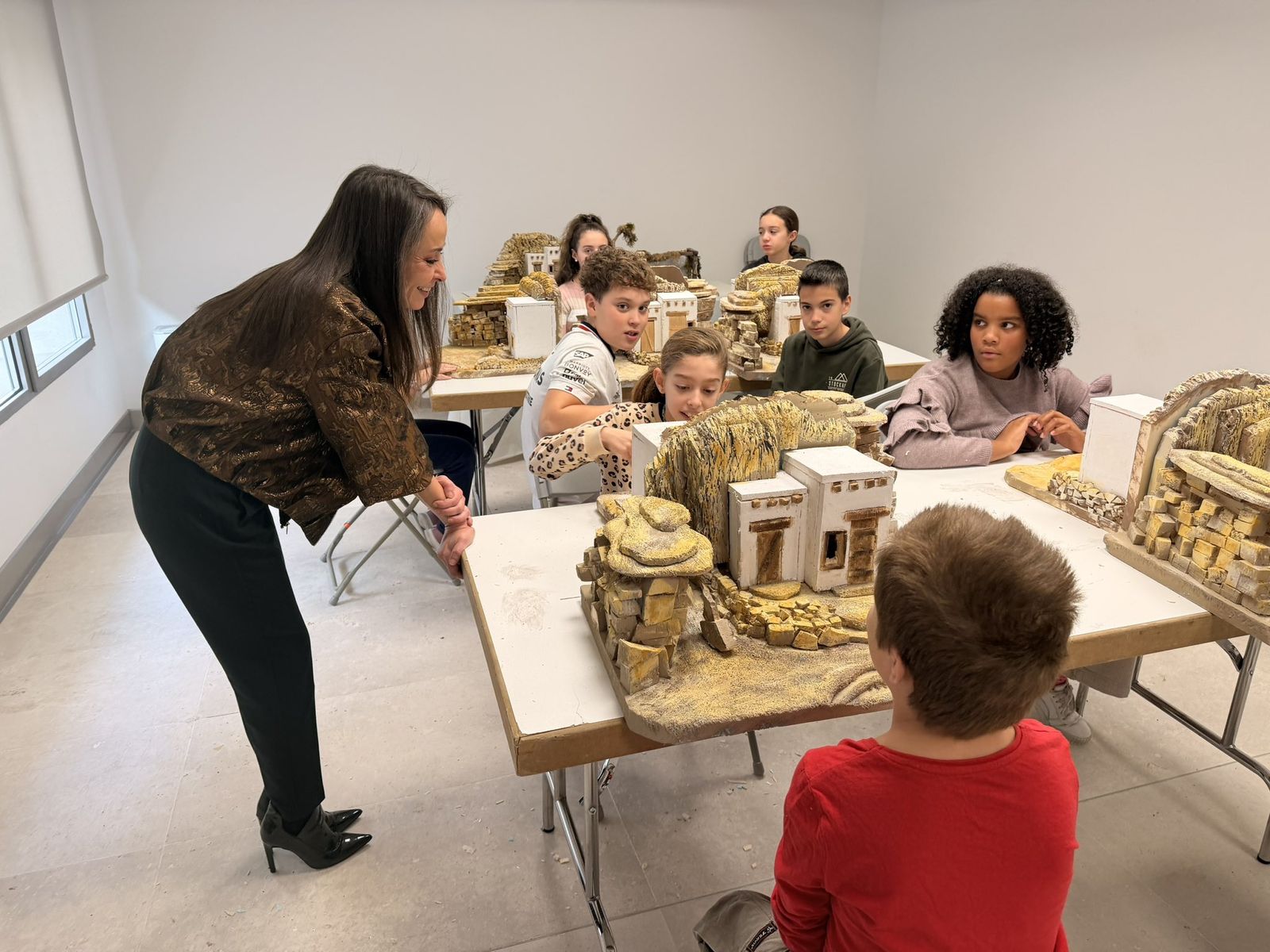 La concejala de Tradiciones, Carmen Seguín, entrega los diplomas a los participantes en los talleres de belenes navideños