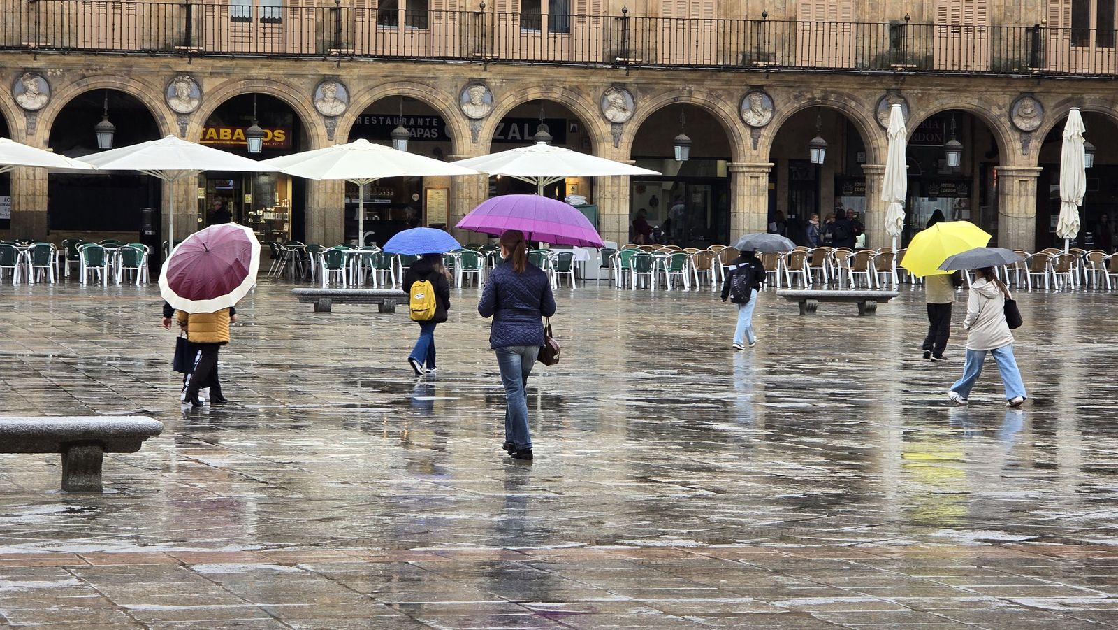 Gente paseando por las Plaza Mayor de Salamanca con paraguas