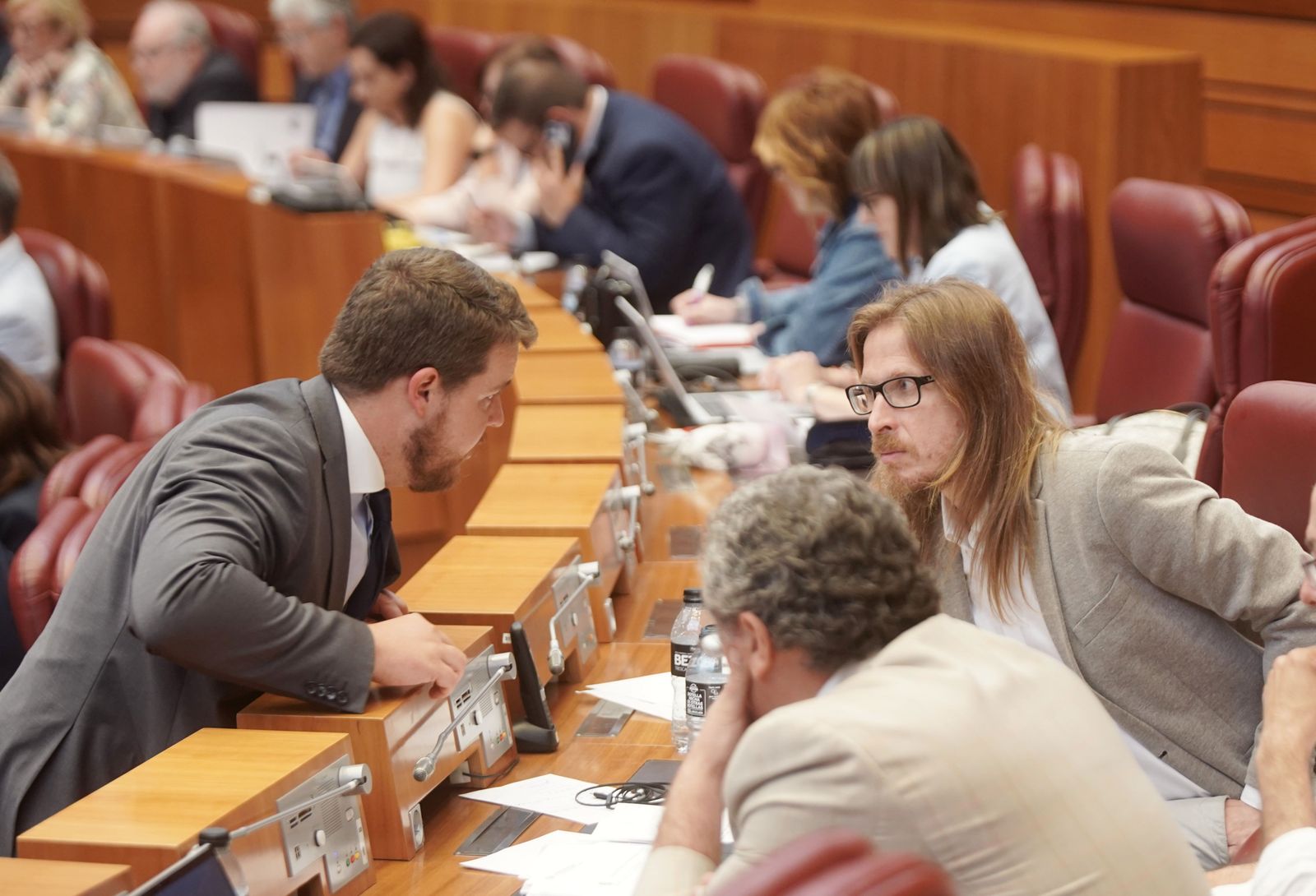 Pleno de las Cortes de Castilla y León. Un procurador de Vox y Pablo Fernandez conversanantes de aprobar la ley de publicidad institucional