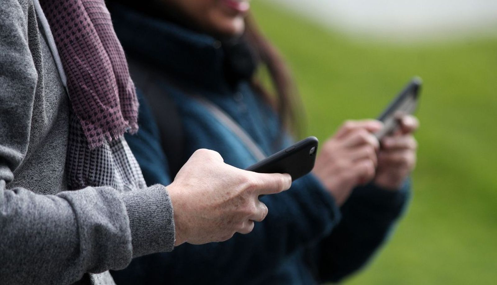 Dos personas hacen uso de sus móviles durante uno de los días que los operadores recopilaron datos de posicionamiento anonimizados y agregados para el estudio de movilidad del INE.