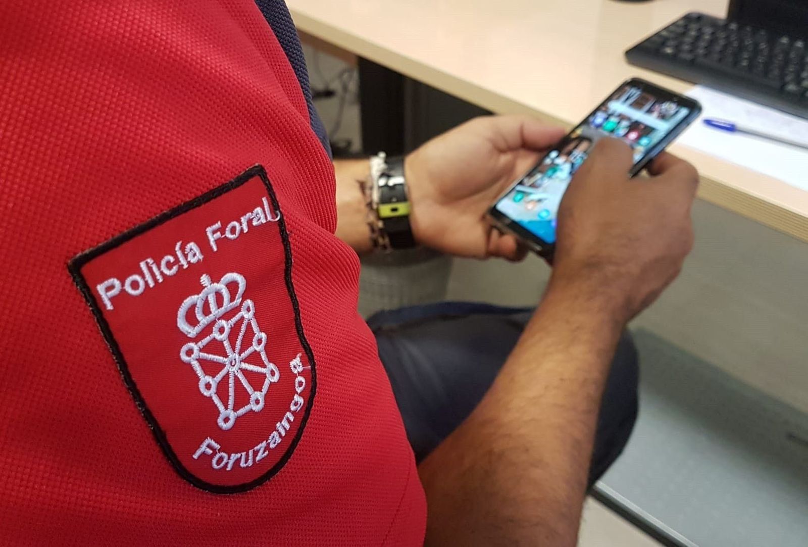 Un agente de la Policía Foral investiga un teléfono móvil