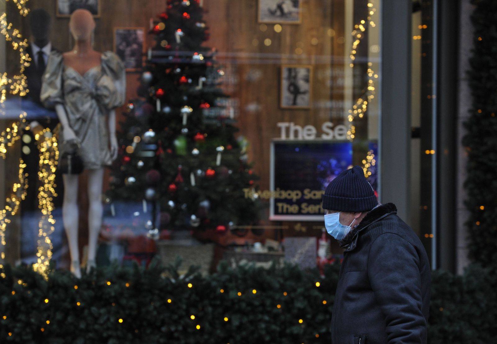 Un hombre con mascarilla ante un escaparate. EP