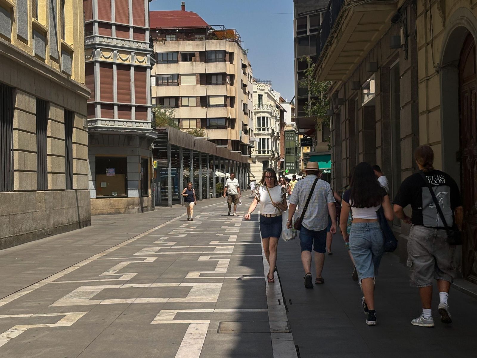 Varias personas se cobijan a la sombra de Santa Clara en un caluroso día de verano