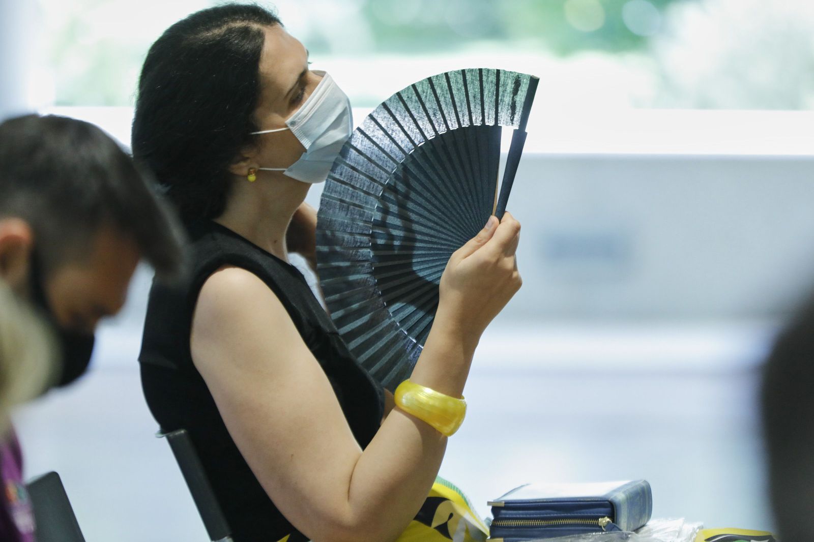 Una mujer con mascarilla se abanica en Madrid (España), a 29 de junio de 2020. El calor pone desde este lunes en aviso a una quincena de provincias de Andalucía, Castilla y León, Castilla-La Mancha