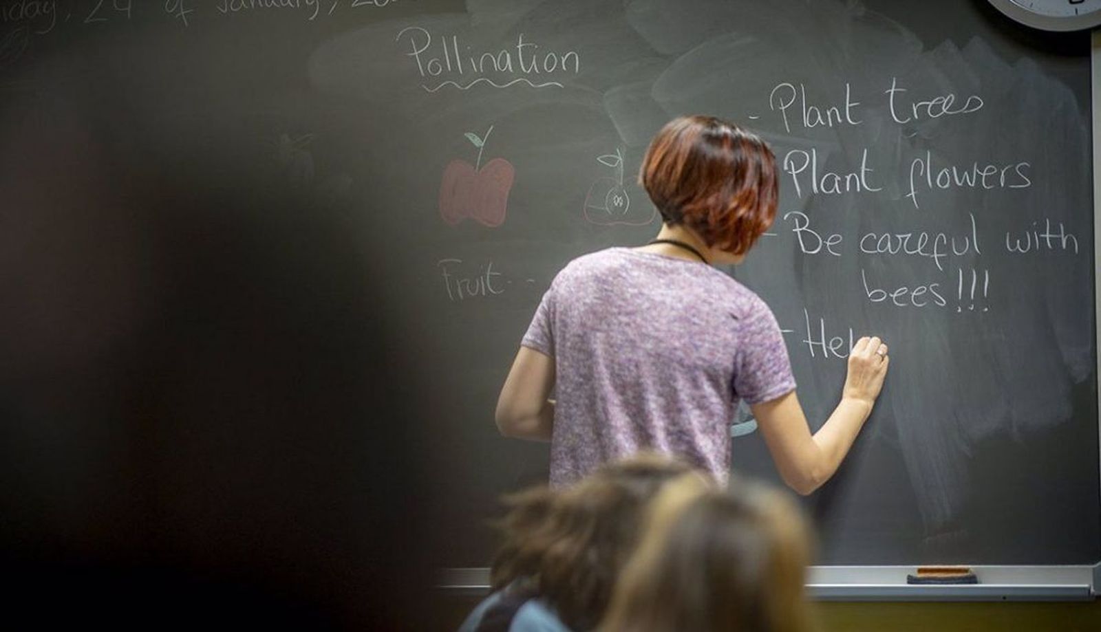 Docente escribe en la pizarra Docente escribe en la pizarra