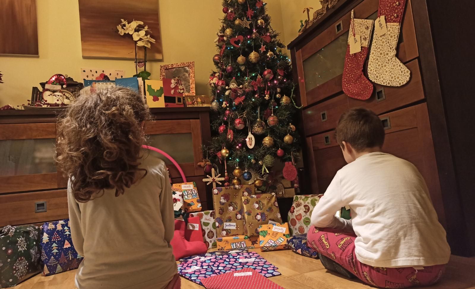 Niños zamoranos frente al árbol de Navidad abriendo sus regalos