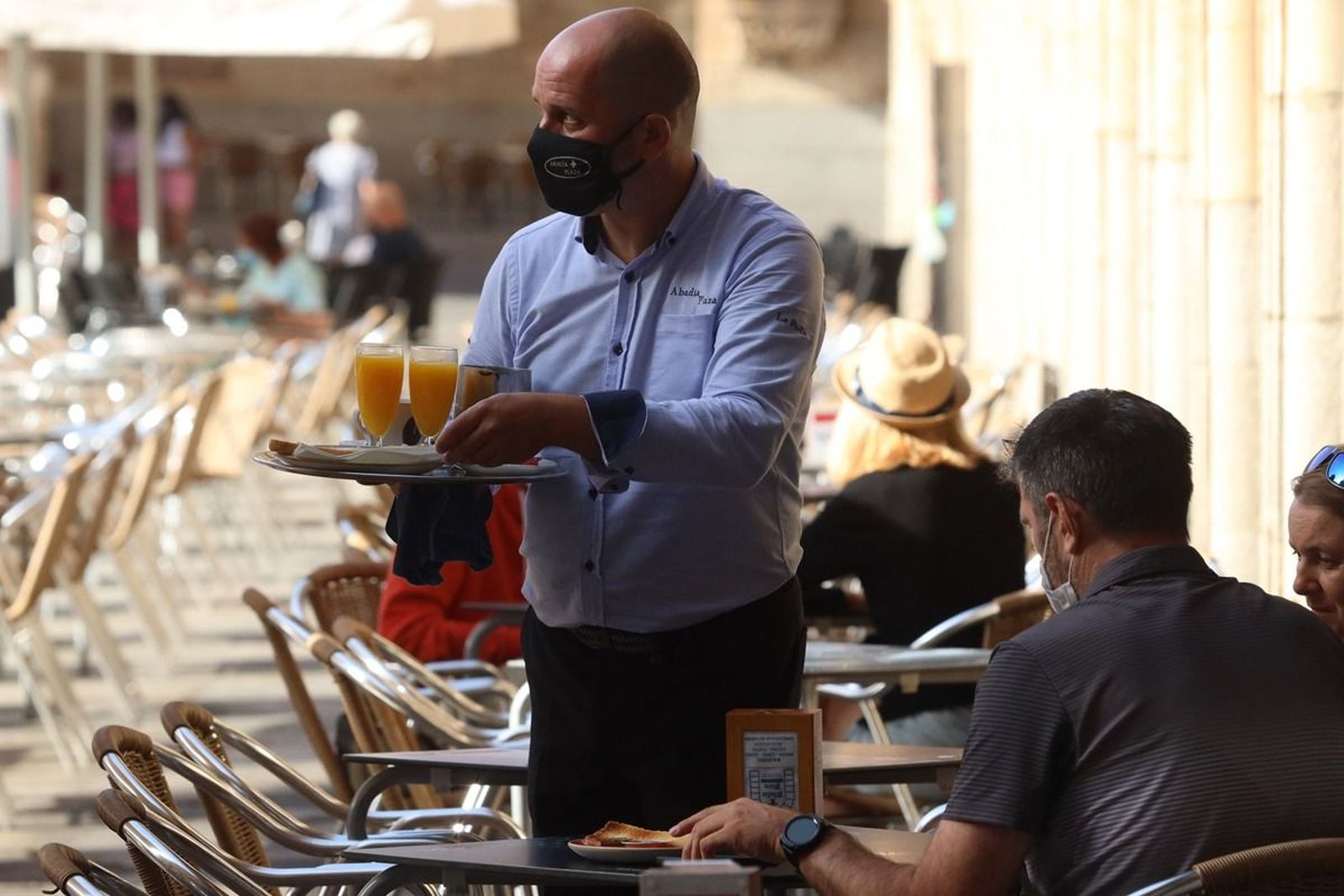Un camarero sirve unos zumos en una terraza de la Plaza Mayor de Salamanca