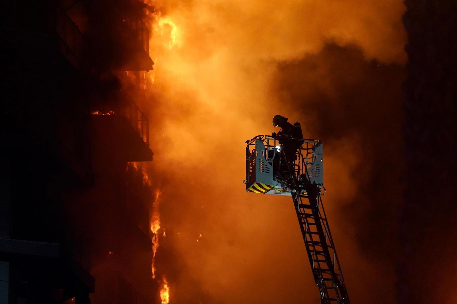 Un bombero trata de apagar el edificio en llamas, en el barrio de Campanar, a 22 de febrero de 2024, en Valencia | Eduardo Manzana - Europa Press
