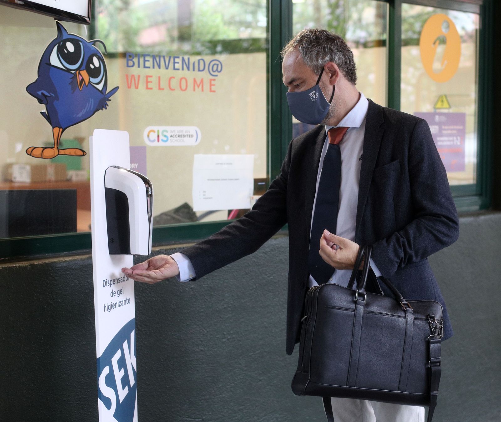 Un trabajador se echa gel antes de entrar en su centro de trabajo
