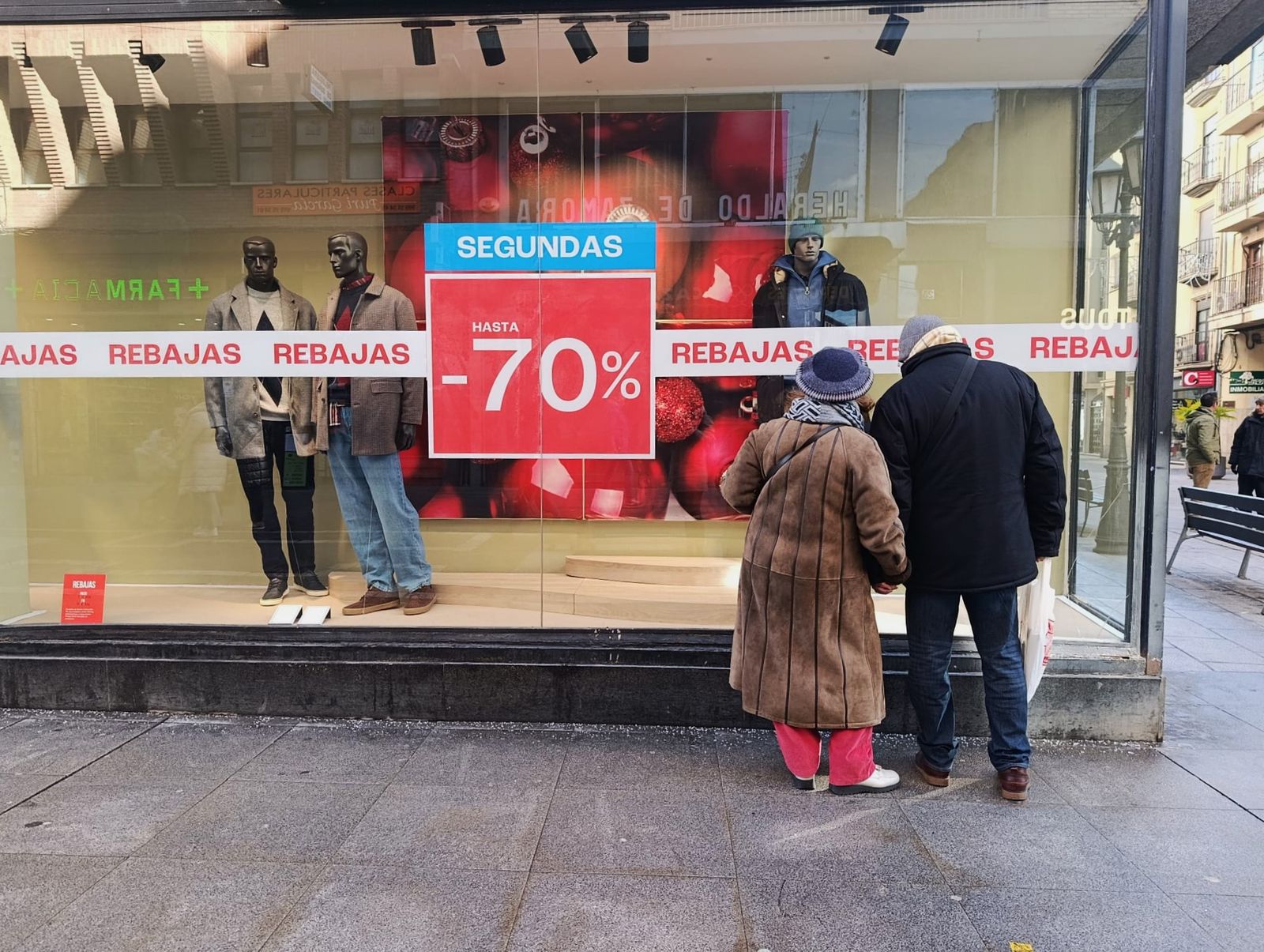 Dos personas observan un escaparate de rebajas en Zamora