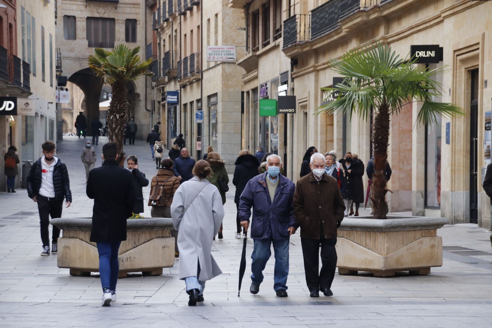 Gente paseando por las calles de Salamanca con paraguas
