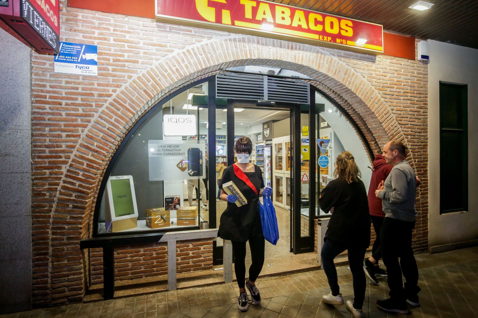 Una mujer sale con mascarilla de un estanco de Pozuelo de Alarcón, el mismo día que el Gobierno ha decretado el estado de alarma en España a consecuencia del coronavirus, en Pozuelo de Alarcón/Mad