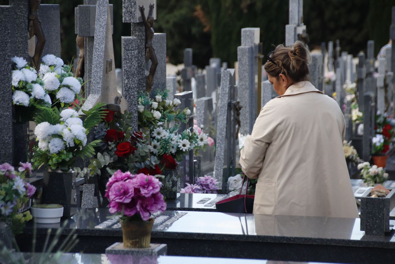 Gente visitando las tumbas de sus familiares en el cementerio