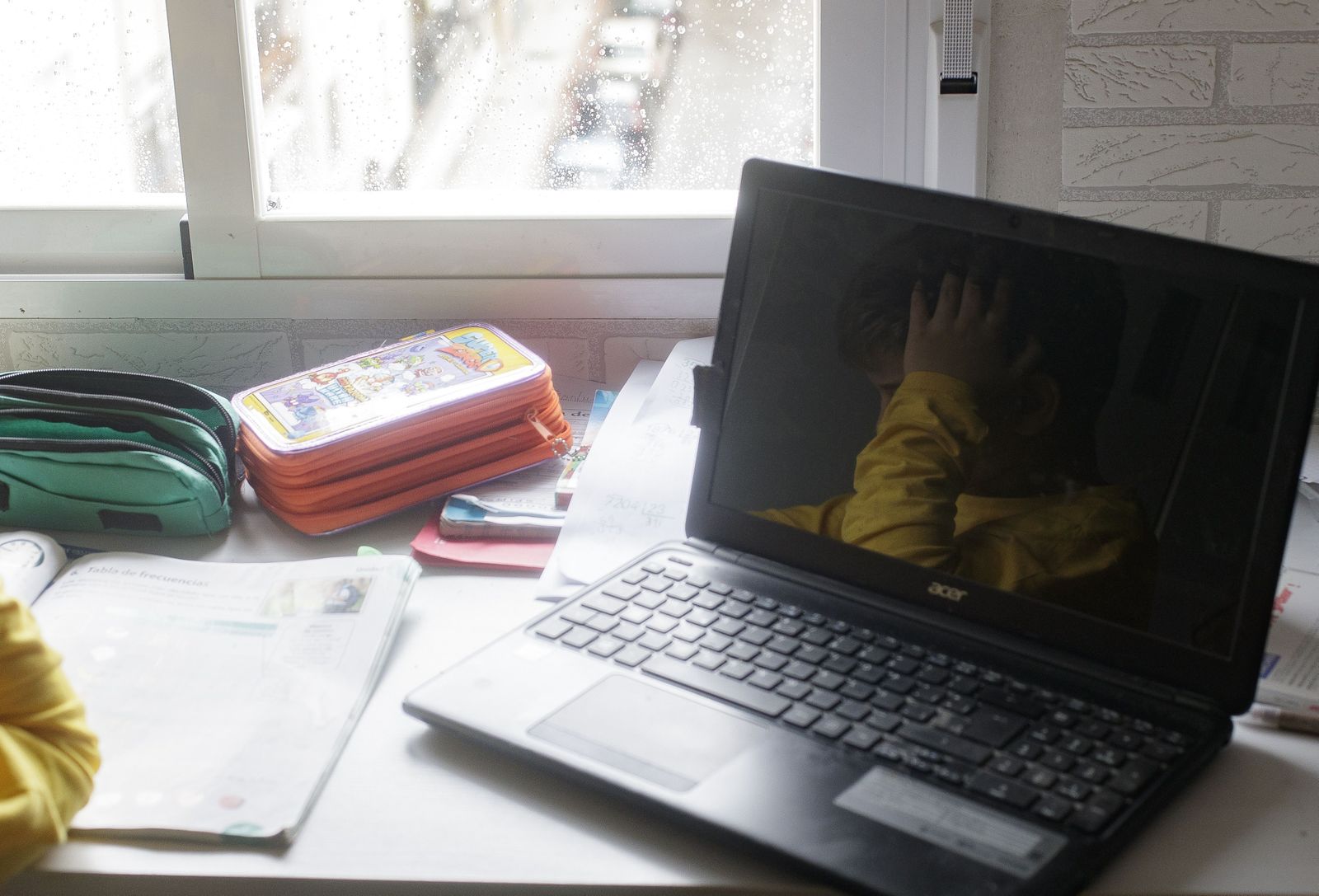 Reflejo en un ordenador portátil de un niño estudiando