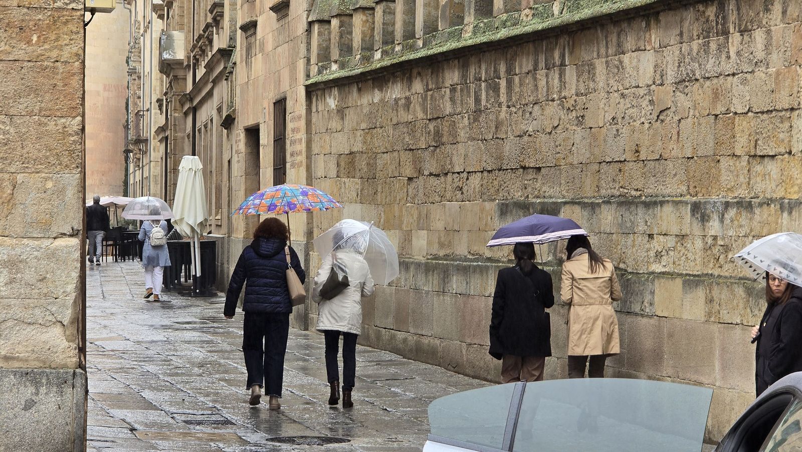 Gente paseando por las calles de salamanca con paraguas
