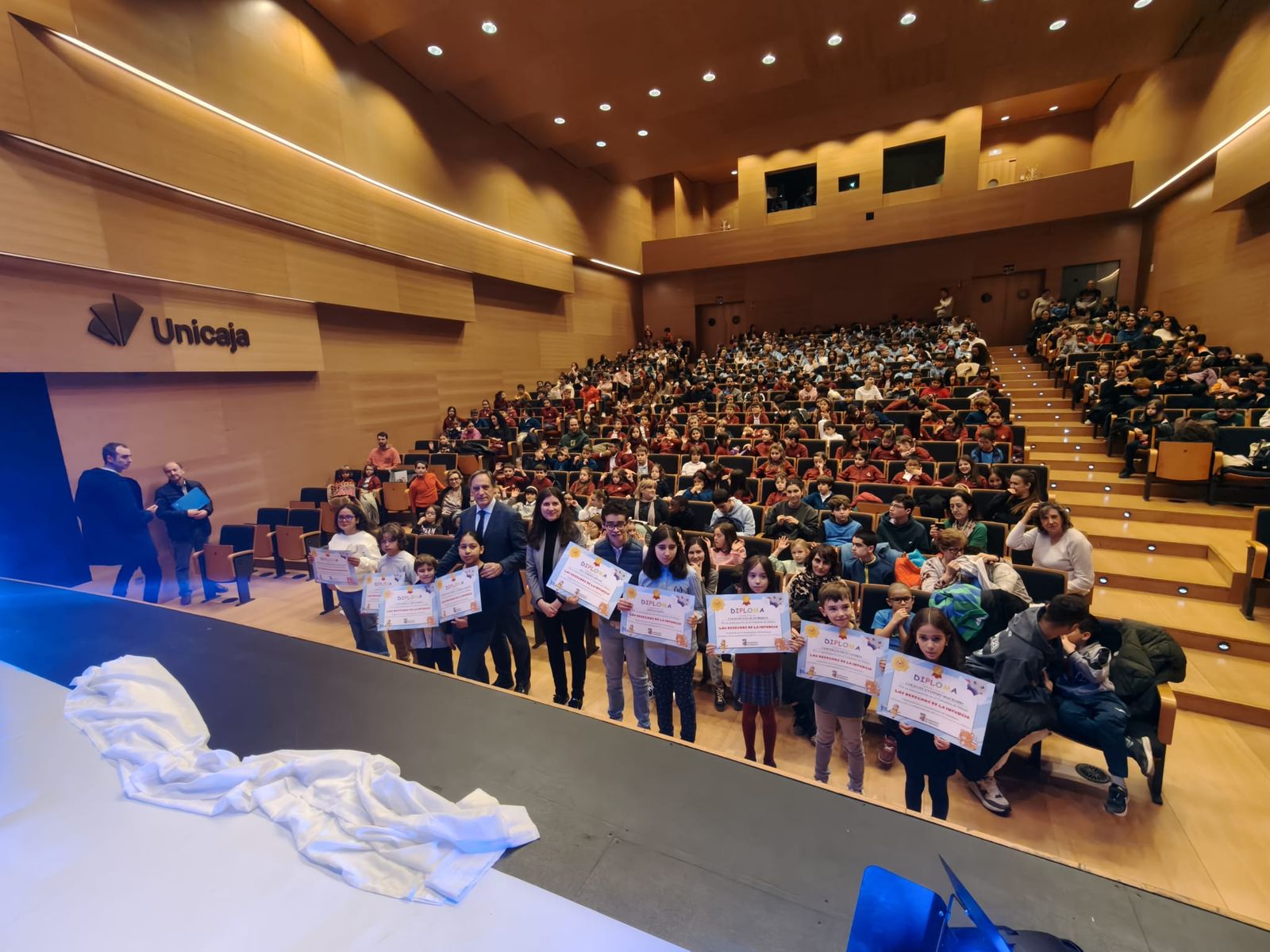 Los niños del concurso de dibujo de reciben sus diplomas premiados de las manos del alcalde por el Día Internacional de los Derechos de la Infancia