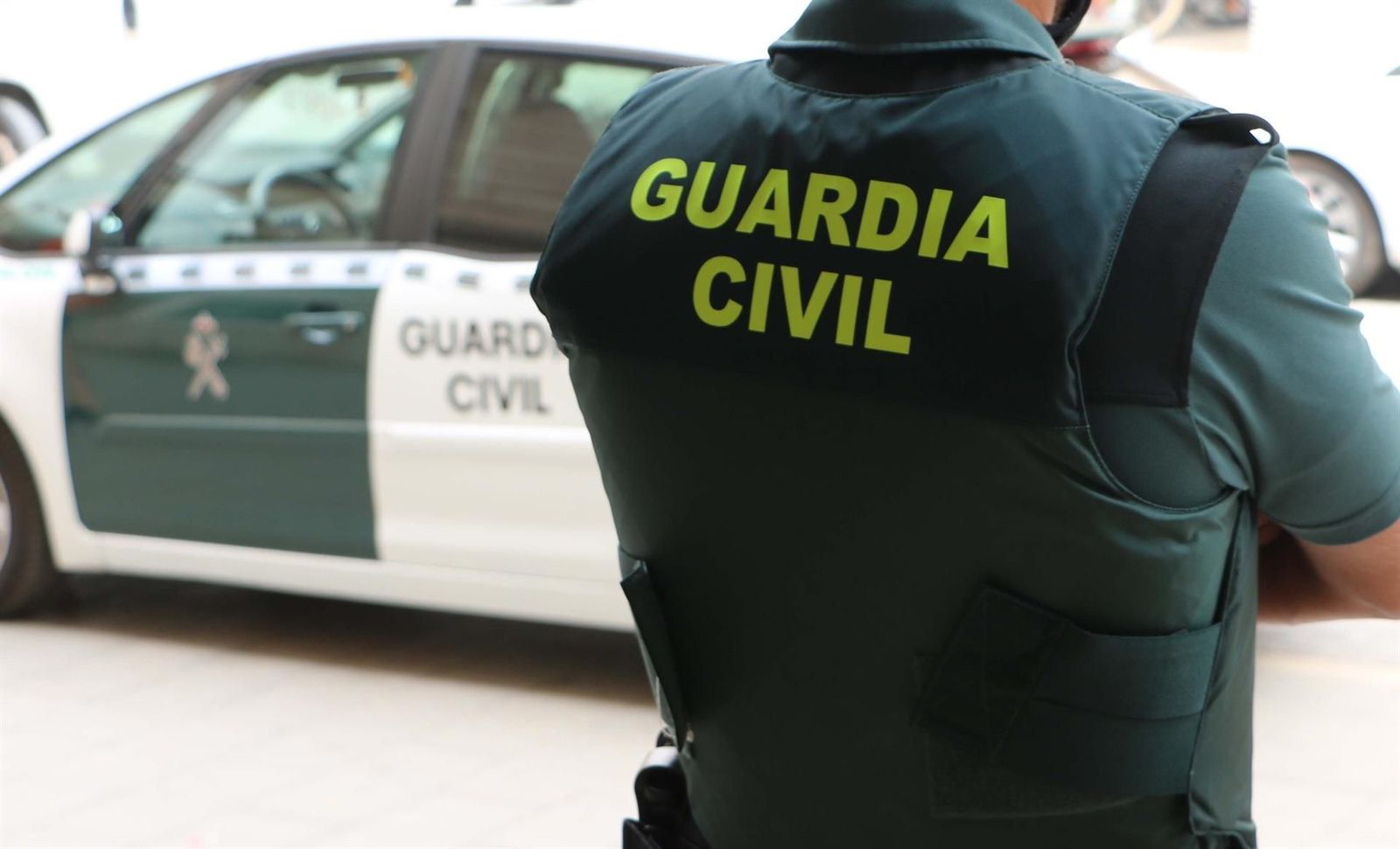 Un agente de la Guardia Civil, de espaldas, junto a un vehículo oficial. FOTO GC EP