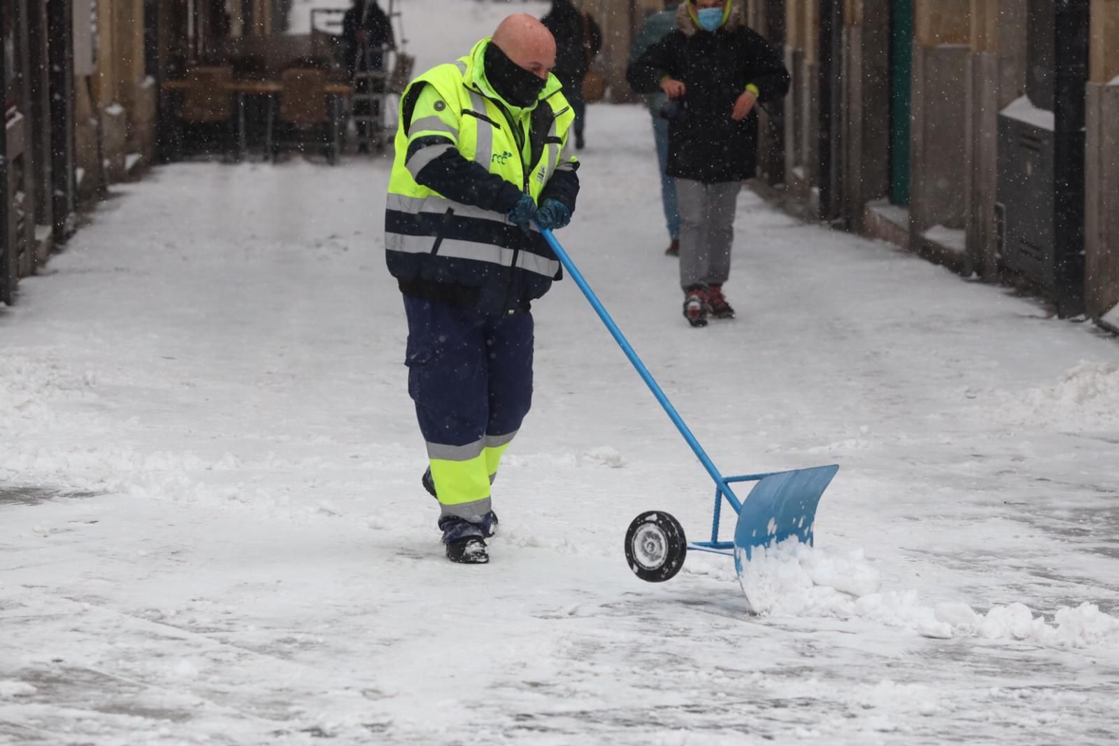 Un operario de limpieza, retirando hielo y nieve