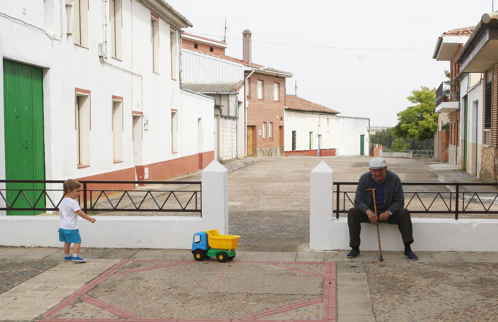 Un pequeño juega junto a una persona mayor en una localidad de Castilla y León. Archivo