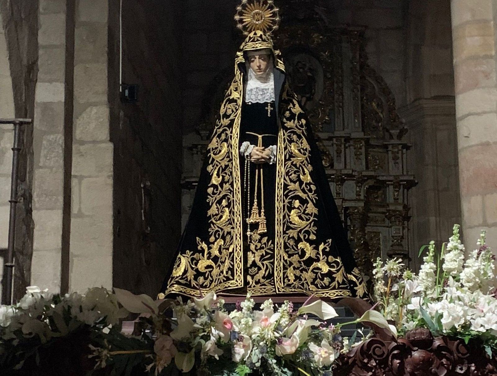 Imagen de la Virgen de la Soledad sobre su mesa procesional con el hábito de Viernes Santo