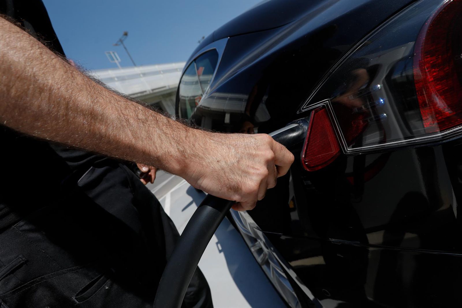 Una persona recarga un coche eléctrico en un punto de recarga. EP