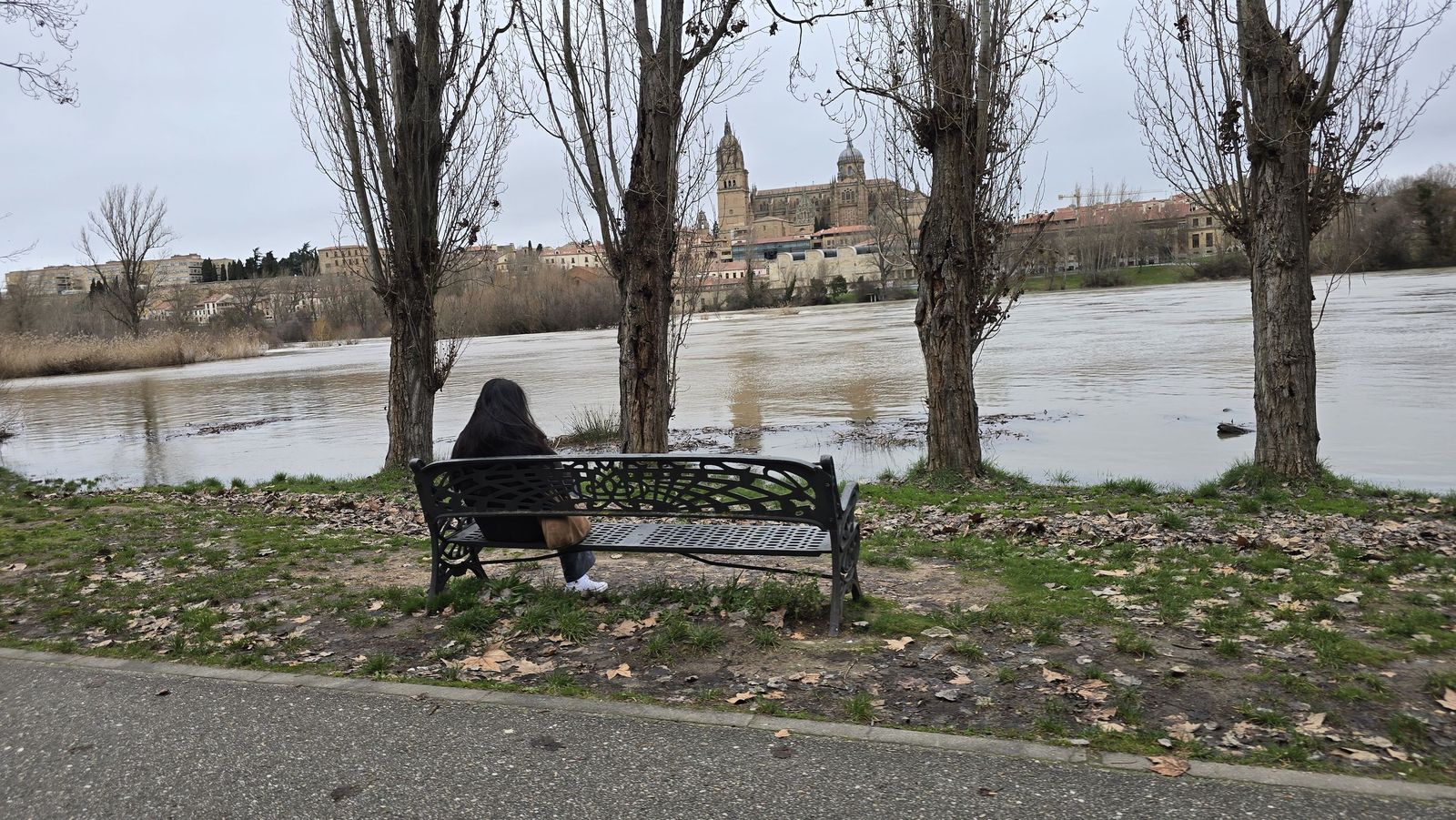 Mujer observando la crecida del rio Tormes y la Catedral de Salamanca