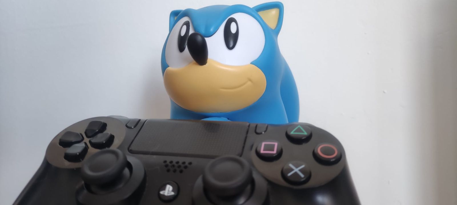 Un muñeco de Sonic (personaje de videojuegos) sostiene un mando de PlayStation 4