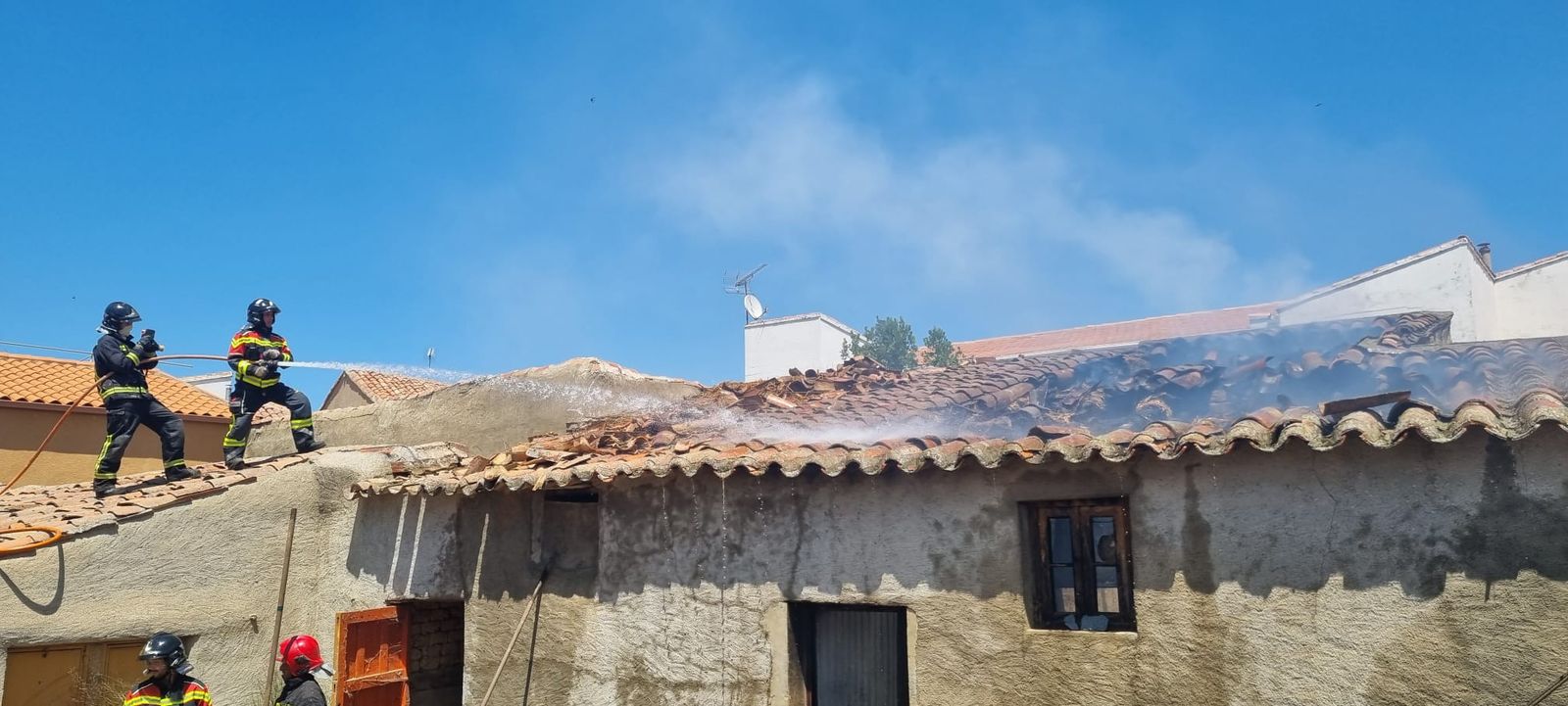 Los bomberos sofocando el fuego en la vivienda