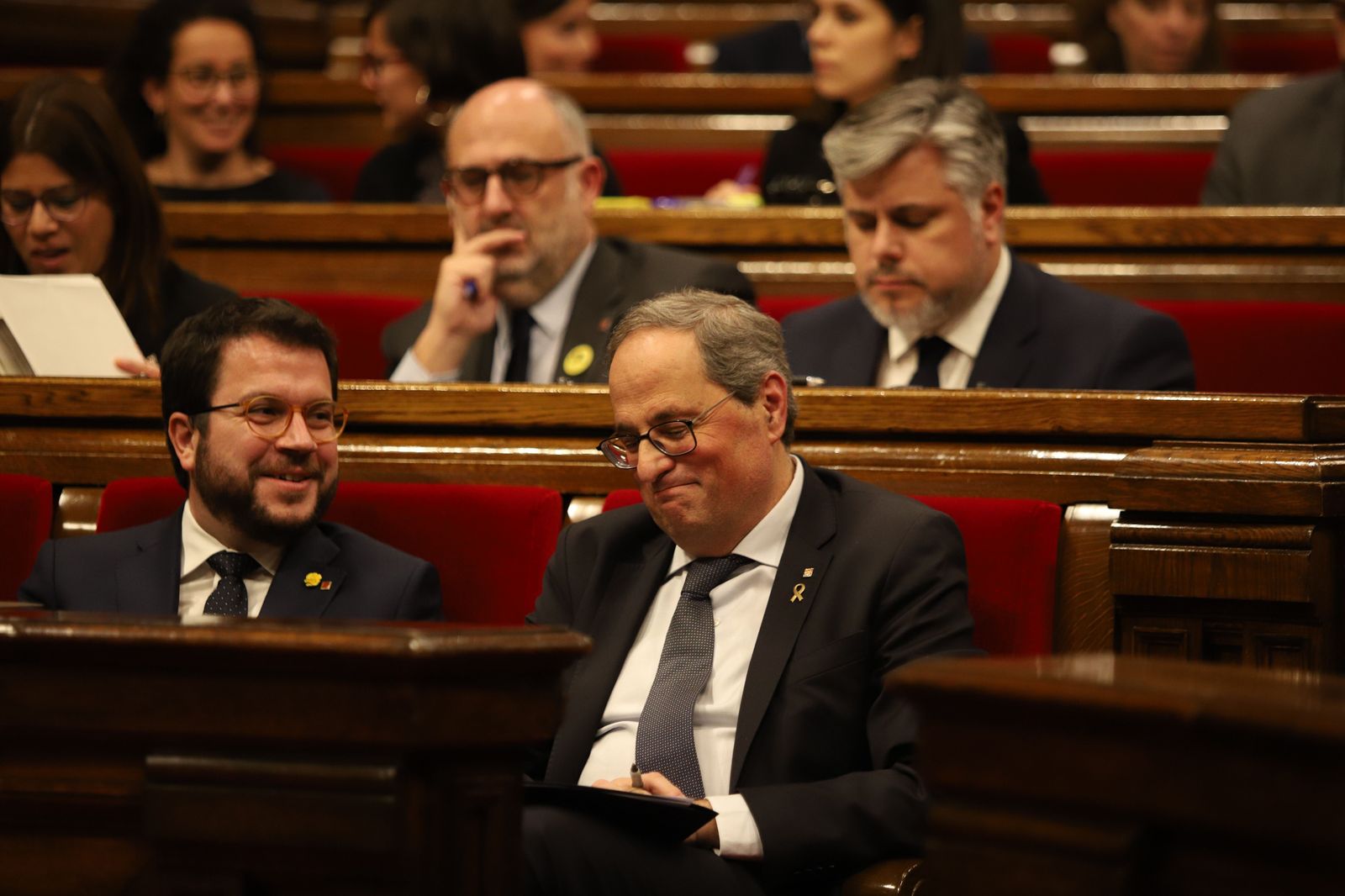 El vicepresident y el president de la Generalitat, Pere Aragonès y Quim Torra, sonríen en sus escaños durante un pleno extraordinario convocado tras la decisión de la Junta Electoral Central (JEC)