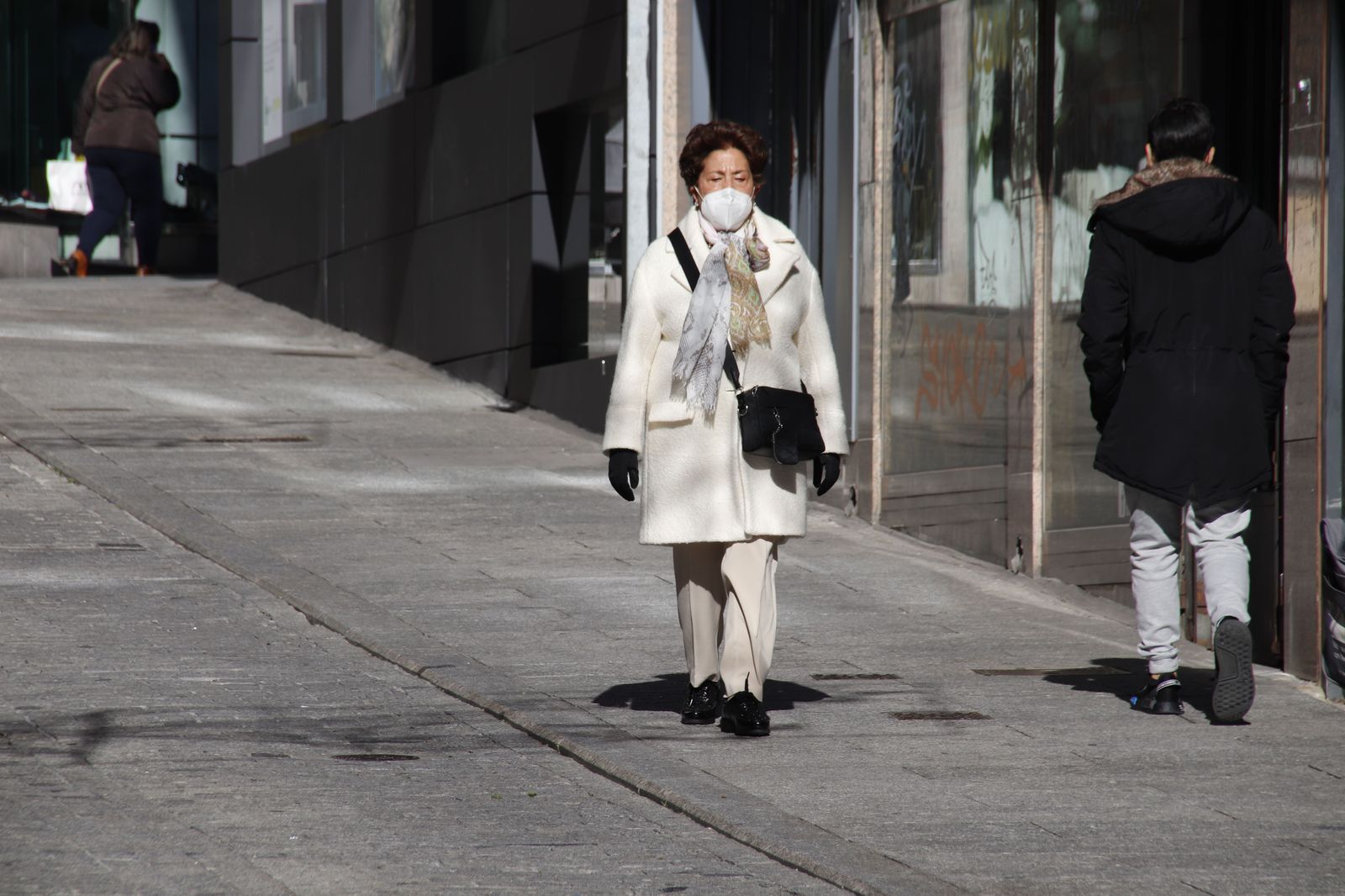 Señora paseando en invierno con bufanda y abrigo por el frío