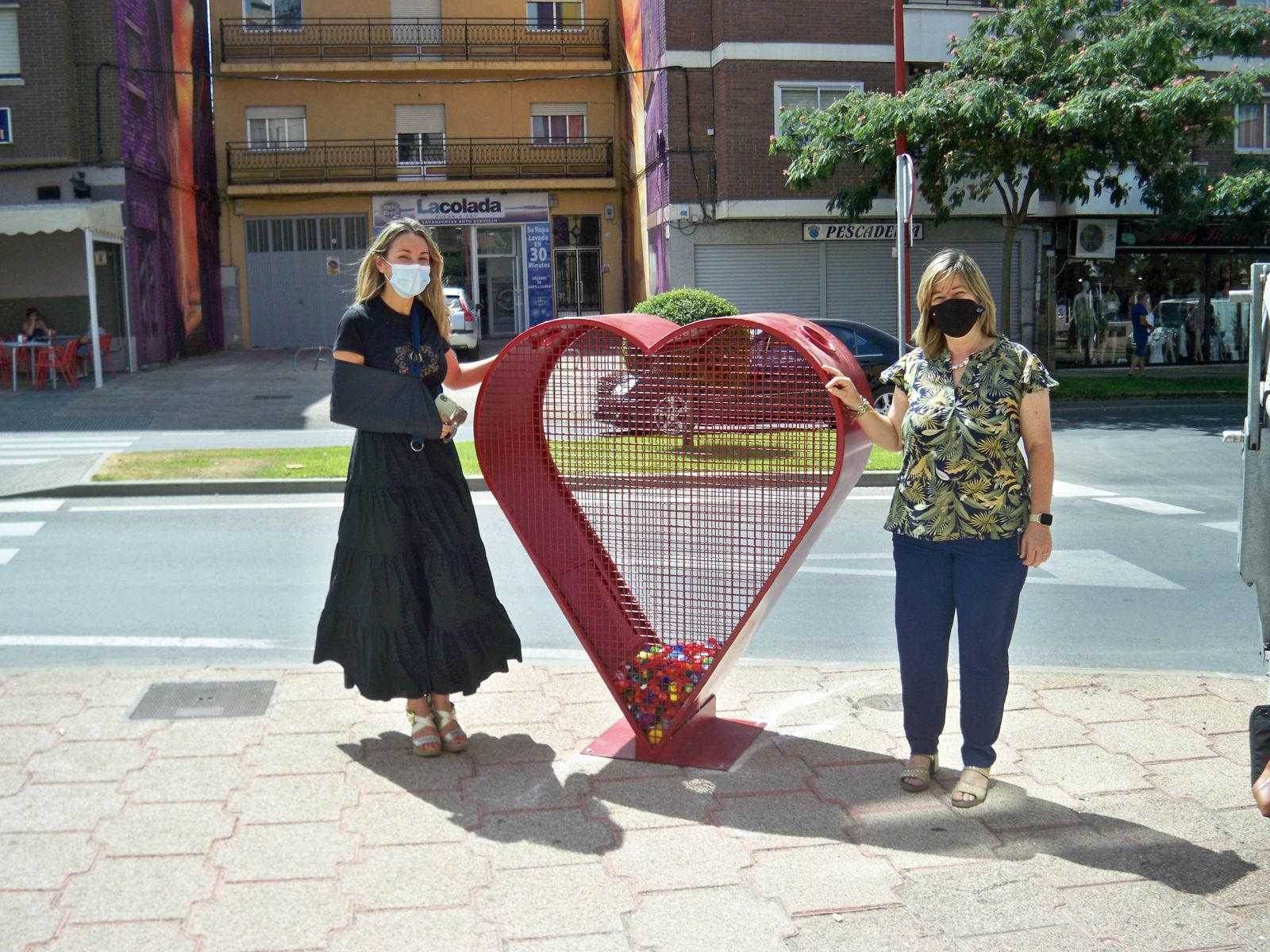 Las concejalas de Medio Ambiente y de Infancia junto al contenedor de tapones de plástico