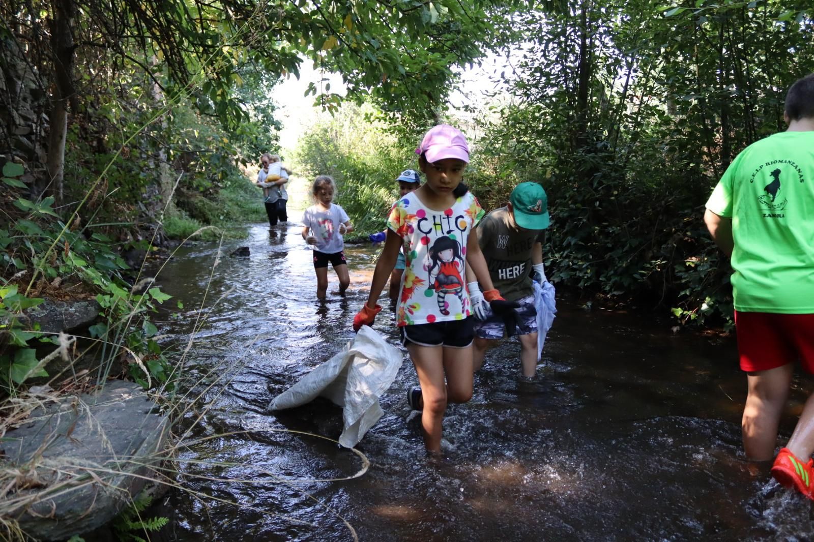 Los niños y las niñas metidos en el río Frío para dejaro limpio de basura. Fotograría Rubén Gago