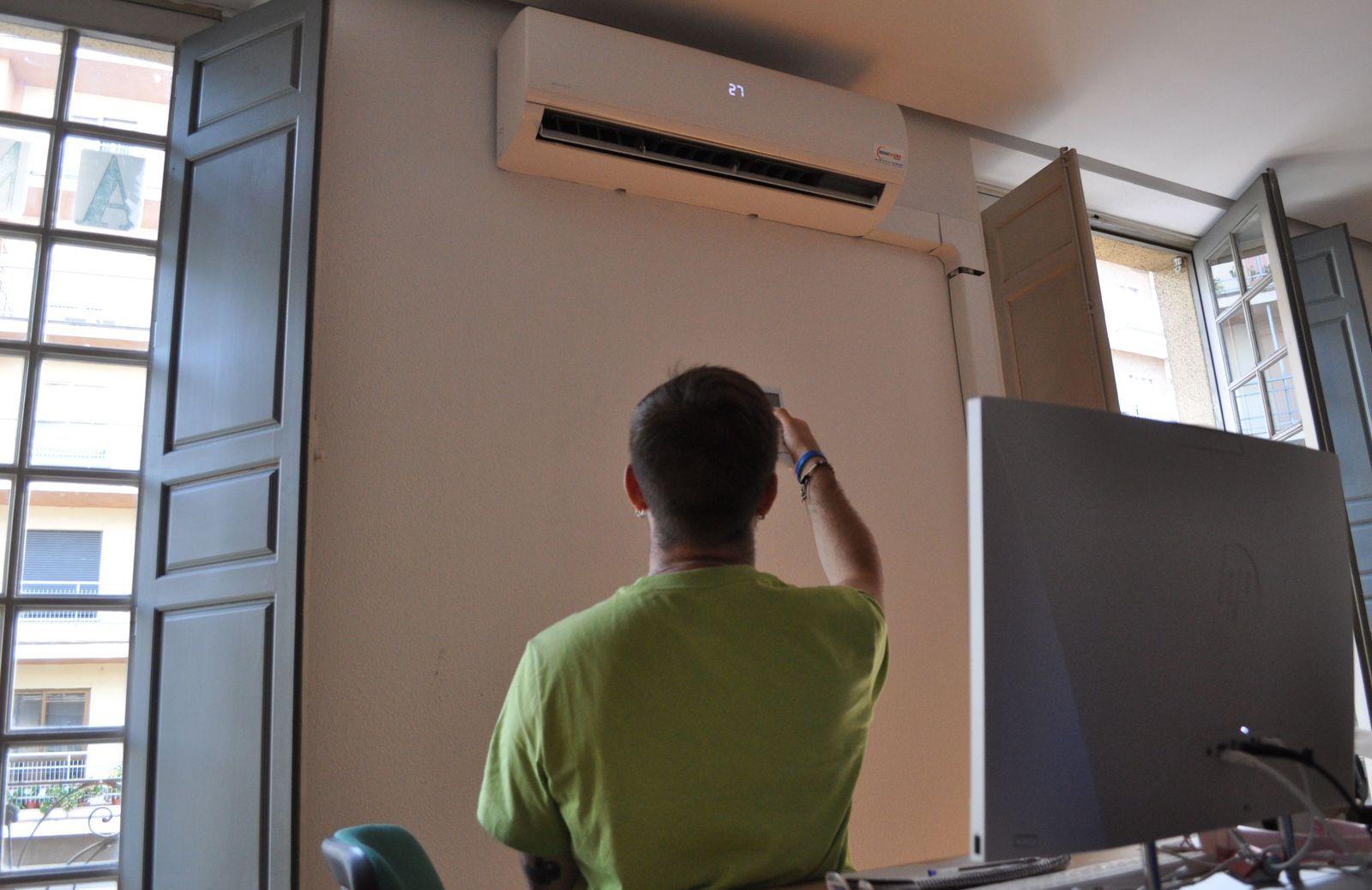 Un trabajador regulando el aire acondicionado