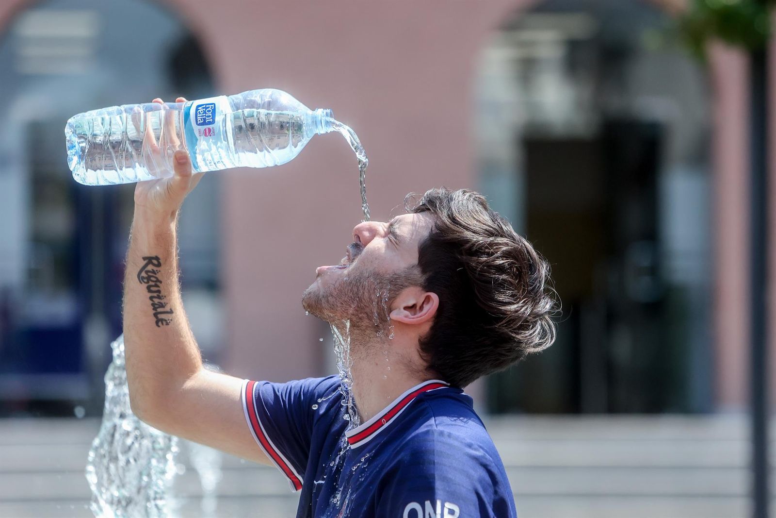 Un joven se tira una botella de agua por encima para combatir el calor. Ricardo Rubio. Europa Press