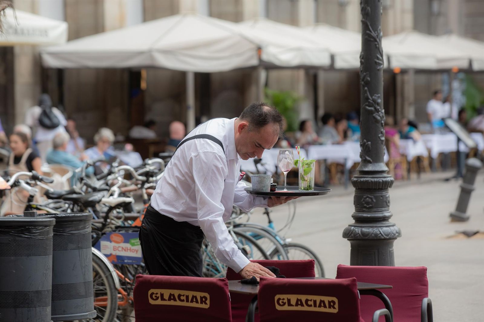 Un camarero limpia una mesa en la plaza Real de Barcelona EP