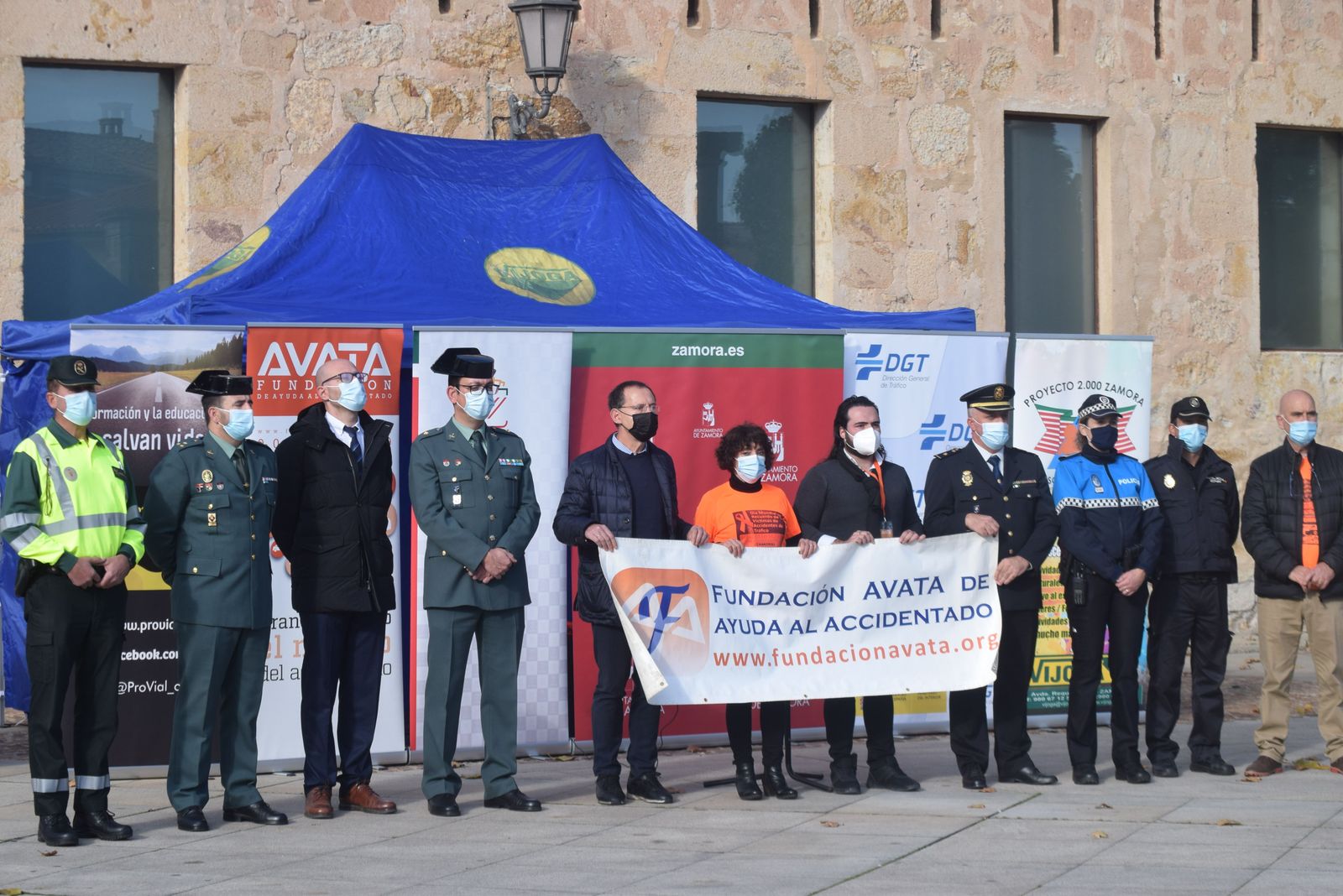 Autoridades portan una pancarta durante el minuto de silencio