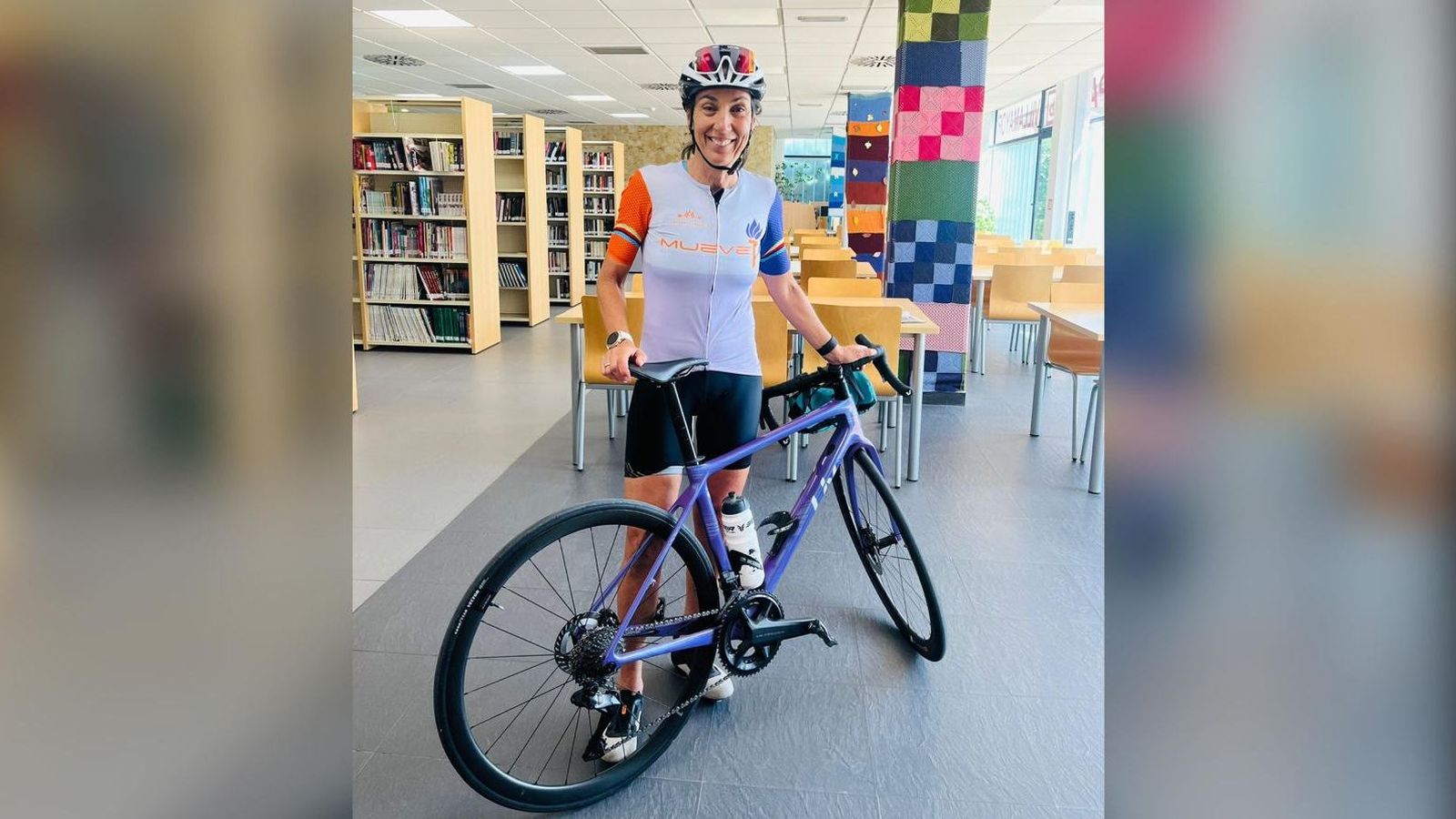 Dori Ruano con su bicicleta en la biblioteca de Villamayor, su localidad natal