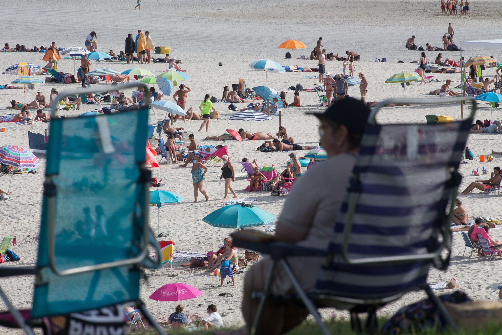 Una persona sentada frente a la playa en A Mariña (Lugo/Galicia) a 27 de julio de 2020. La comarca mantiene este domingo 51 casos activos de COVID-19 tras una nueva alta y un nuevo contagio con respe