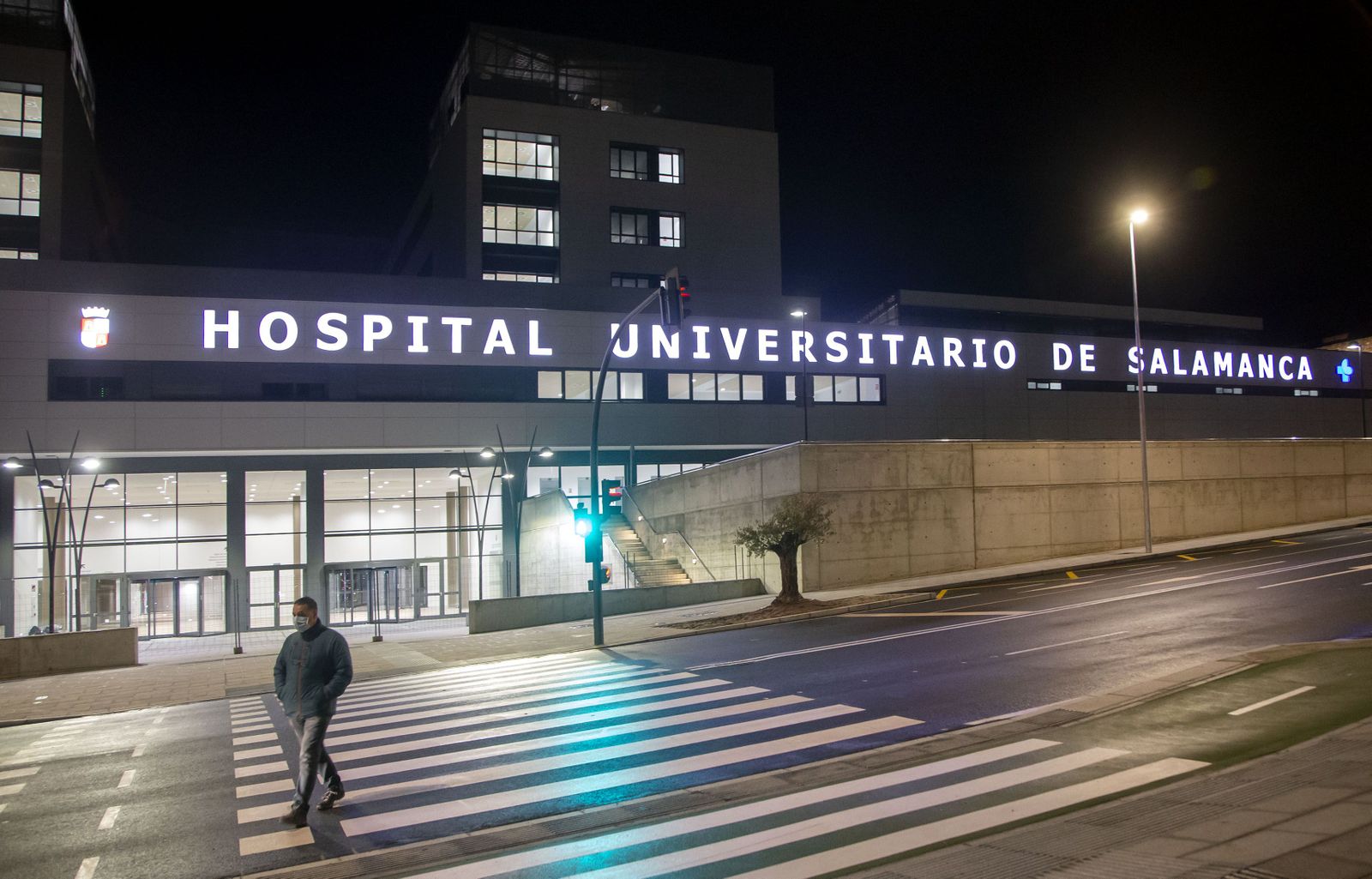 Un peatón camina junto al recién iluminado nuevo hospital de Salamanca ICAL