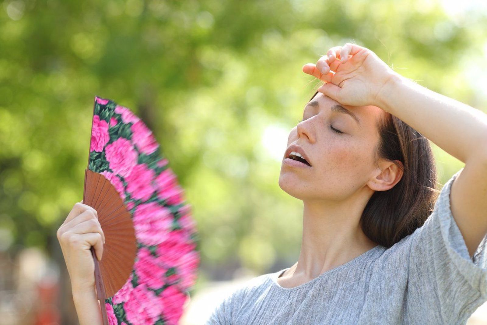 Mujer abanicándose por el sofocante calor
