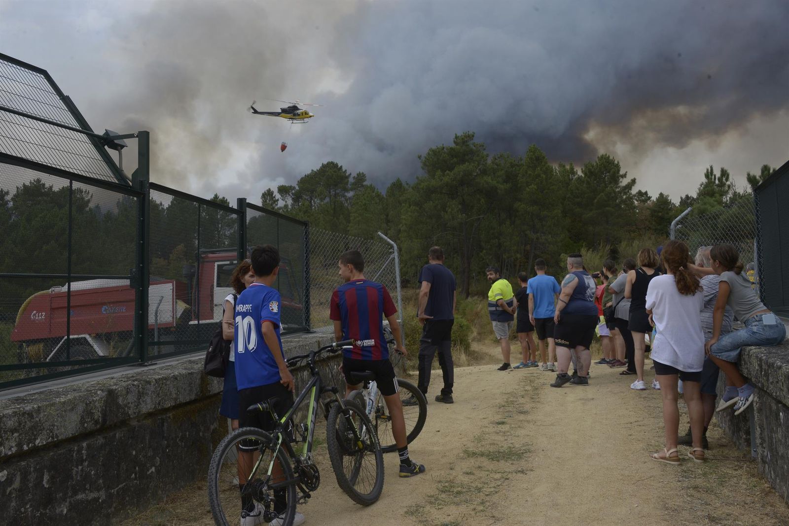 Vecinos y curiosos observan el fuego, a 12 de agosto de 2025, en Seixalbo, Ourense, Galicia (España)