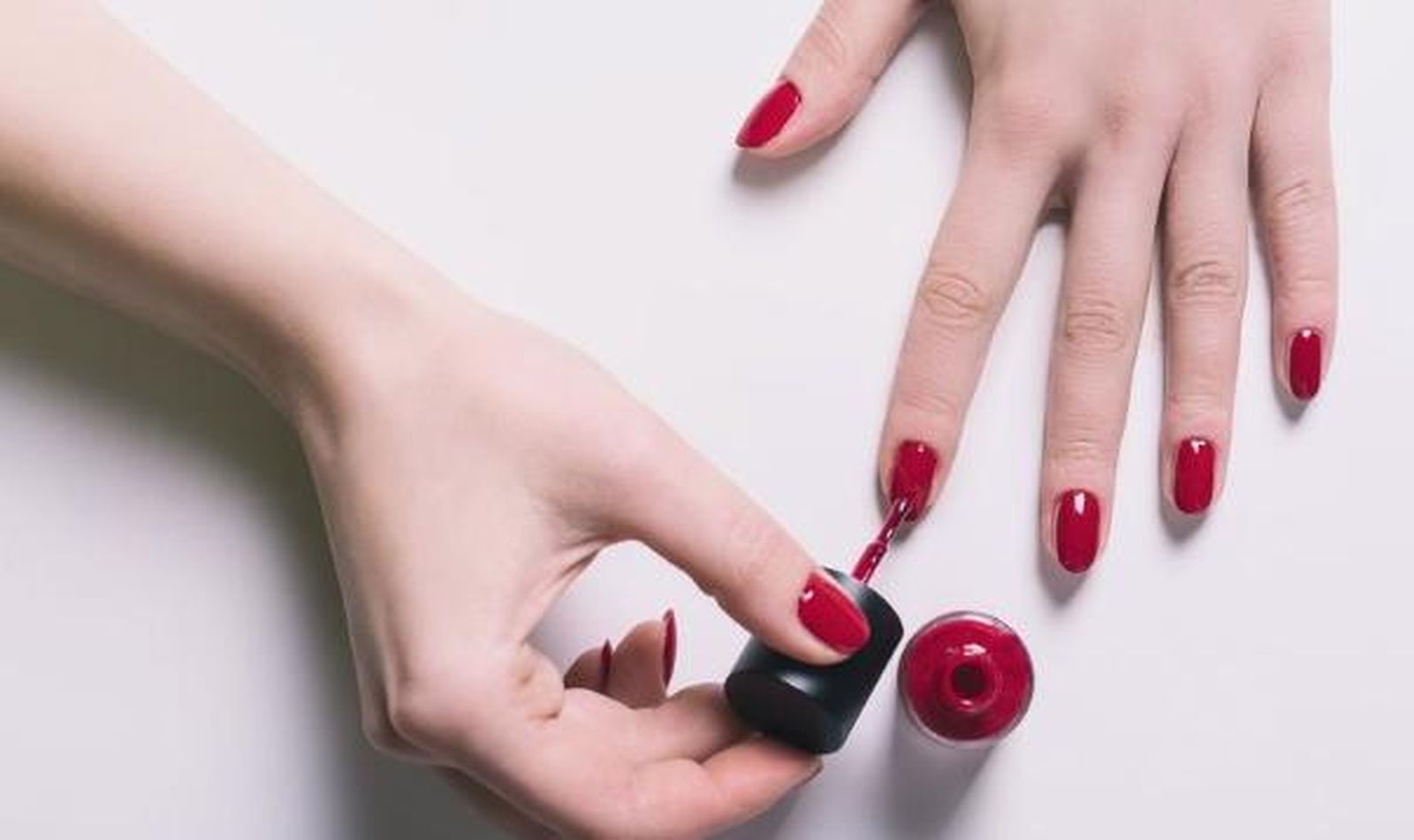 Foto de archivo de una mujer pintándose las uñas