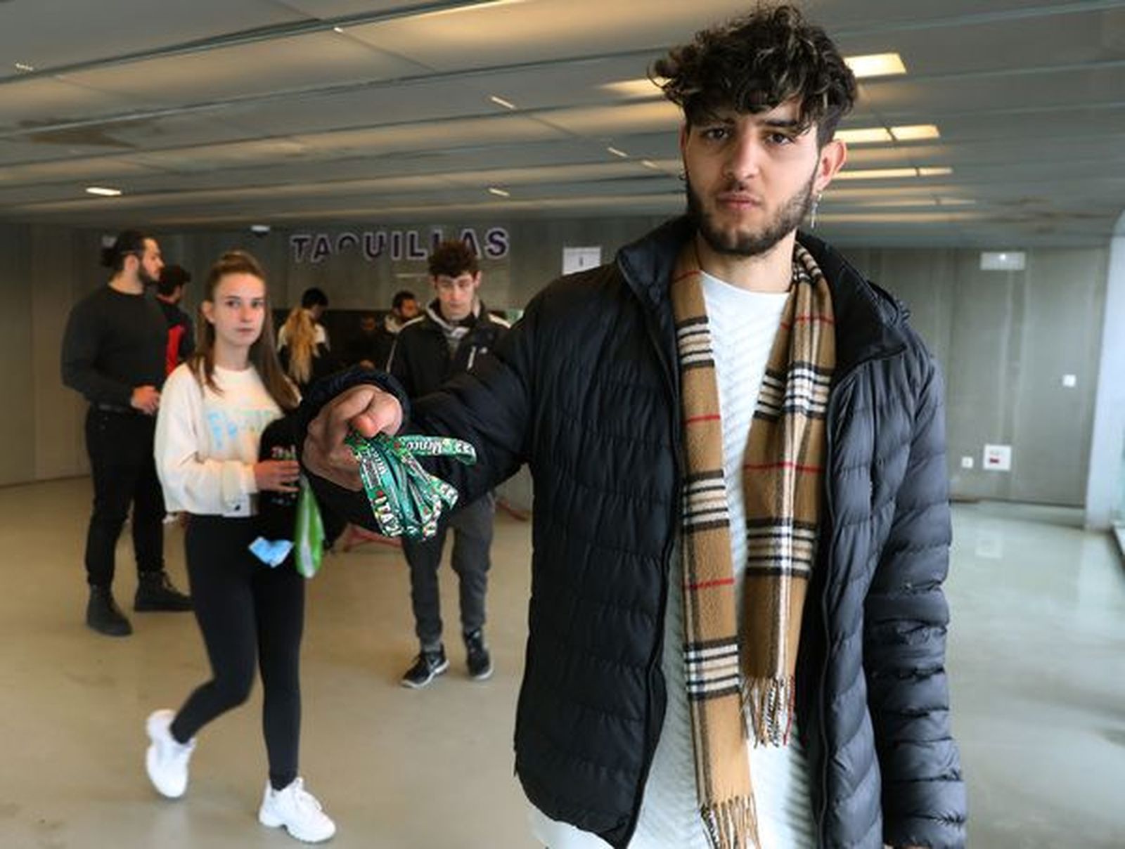 Un joven muestra sus entradas para la ITA