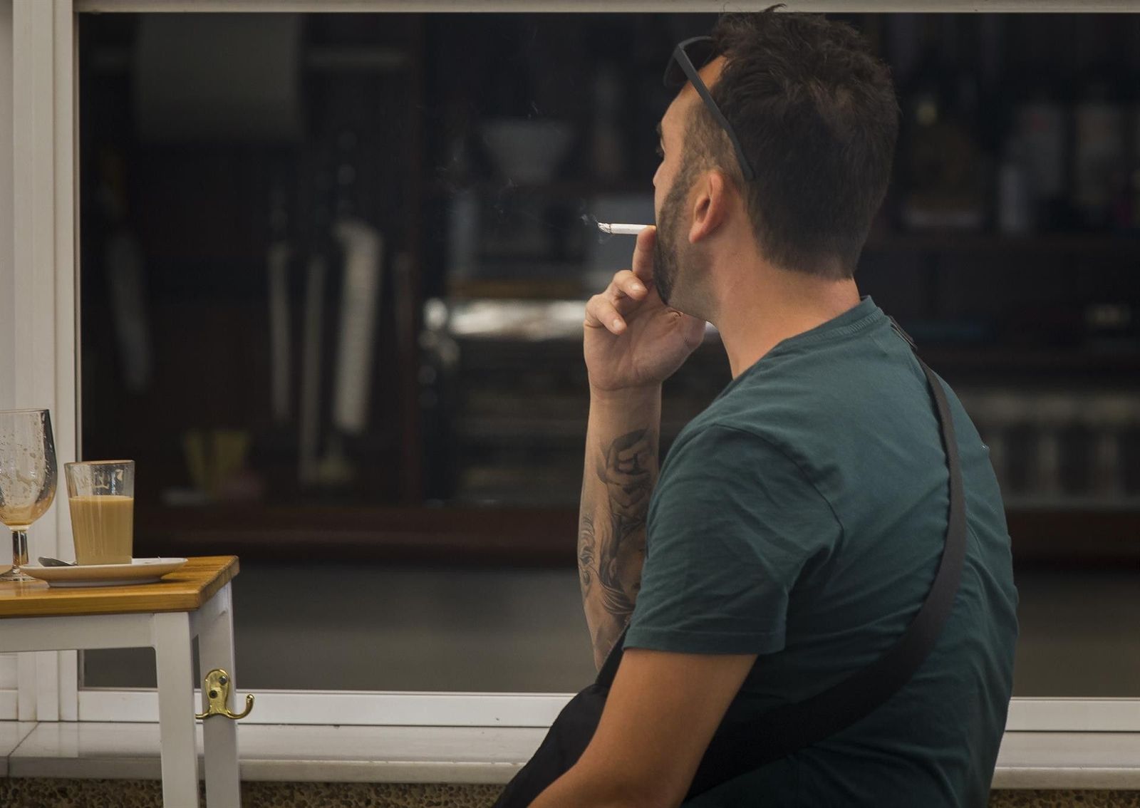 Persona fuma en una terraza