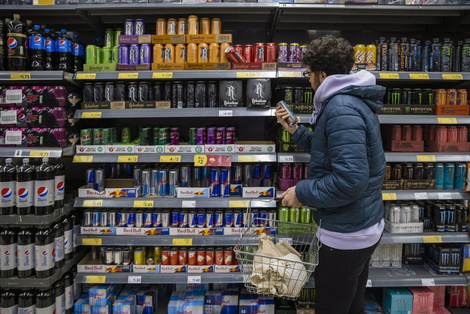 Archivo - Un joven mira la sección de bebidas energéticas en el supermercado. - SOLSTOCK - Archivo