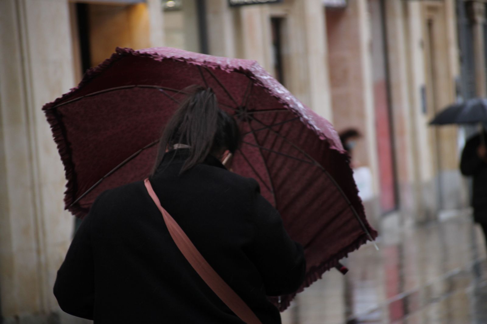 Mujer abre paraguas por la lluvia. Foto de archivo