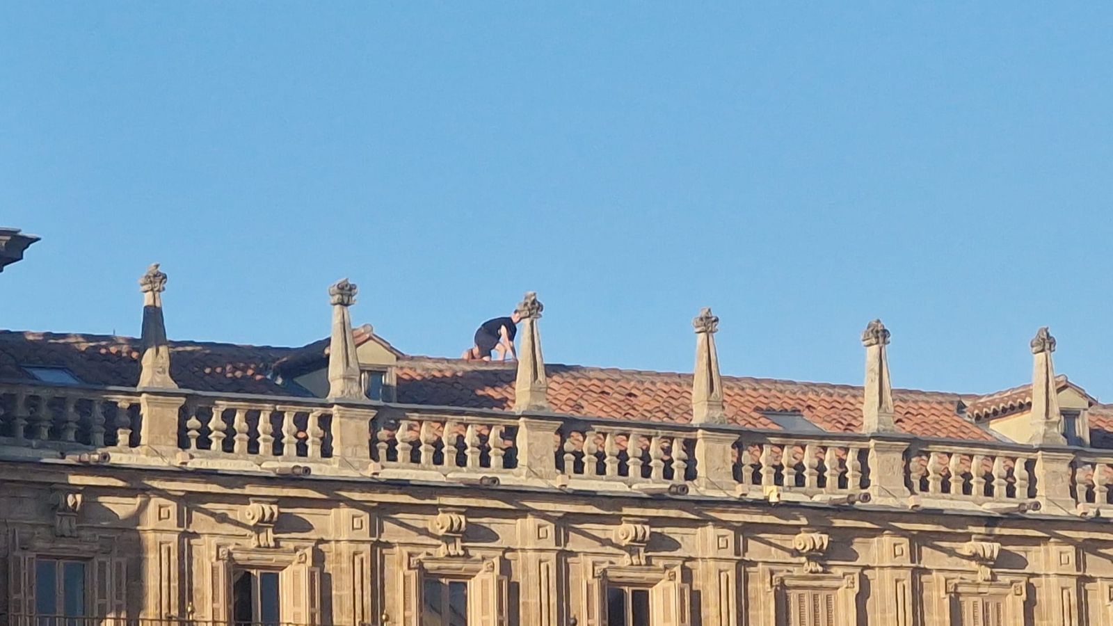 Un grupo de jóvenes accede a los tejados de la Plaza Mayor de Salamanca para hacerse una fotografía